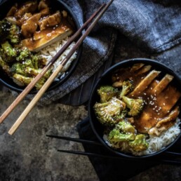 two Chicken Teriyaki Bowls with chopsticks and a napkin