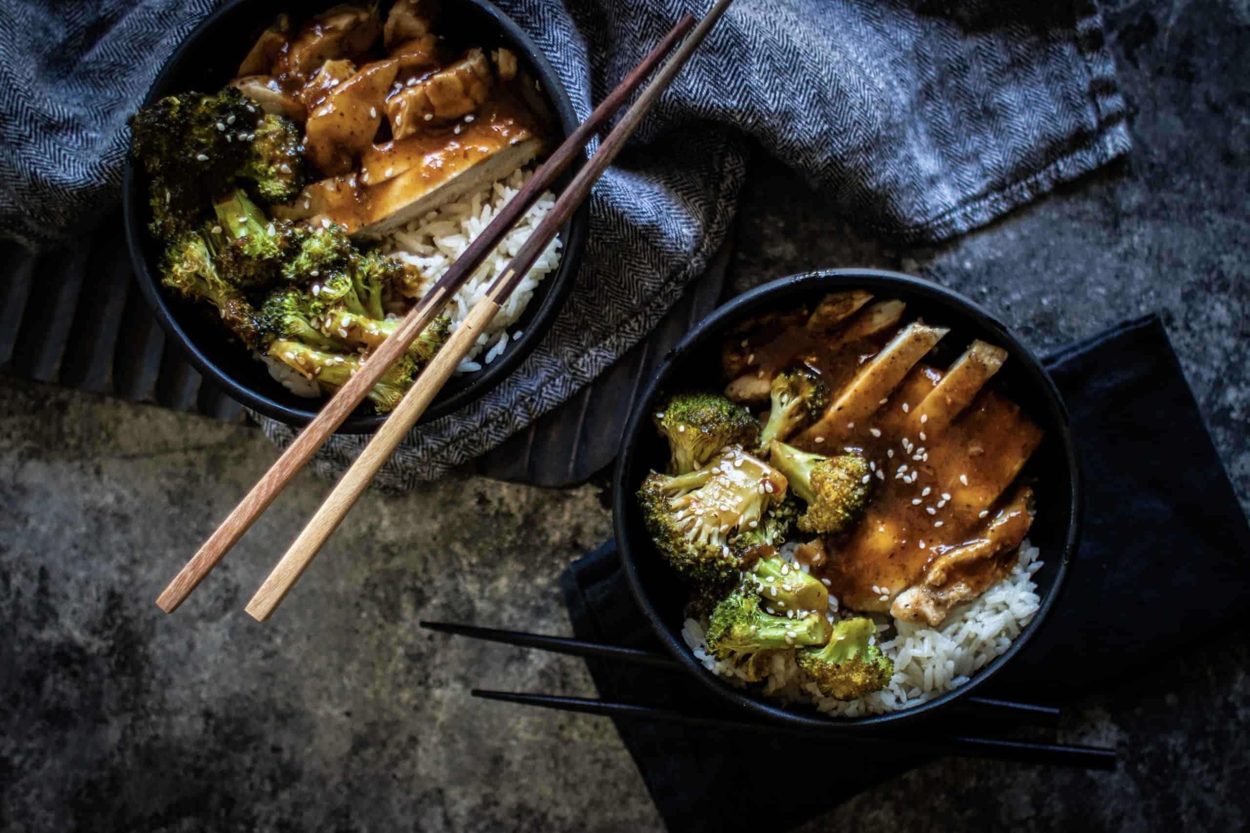 two Chicken Teriyaki Bowls with chopsticks and a napkin