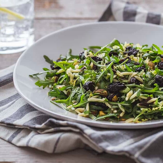 a plate of Orzo and Arugula Salad with California Prunes