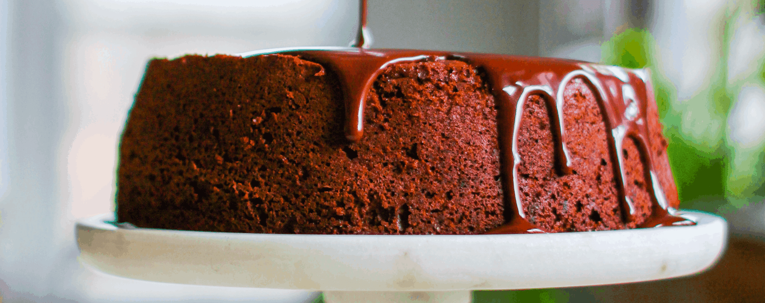 drizzling chocolate fudge on top of a chocolate cake