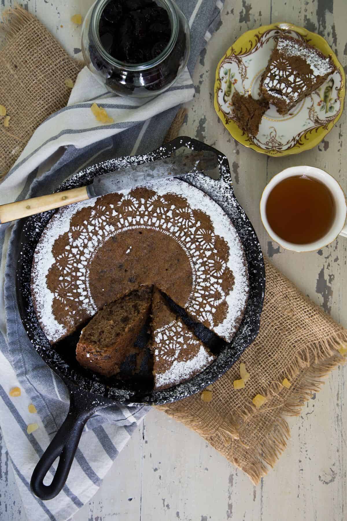 Ginger Prune Skillet Snack Cake in a cast iron pan with a slice removed