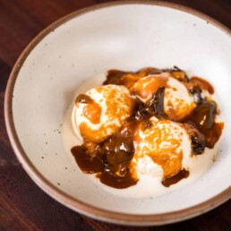 a bowl of ice cream covered in Spiced Prune Caramel