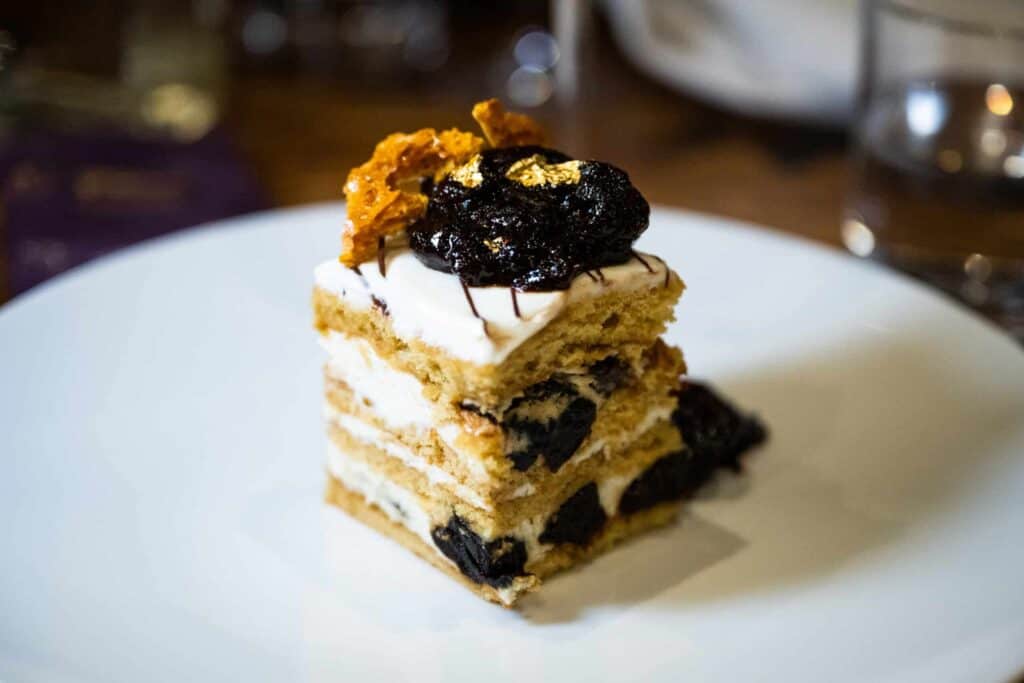 A slice of California Prune and Ukranian Honey Cake on a white plate