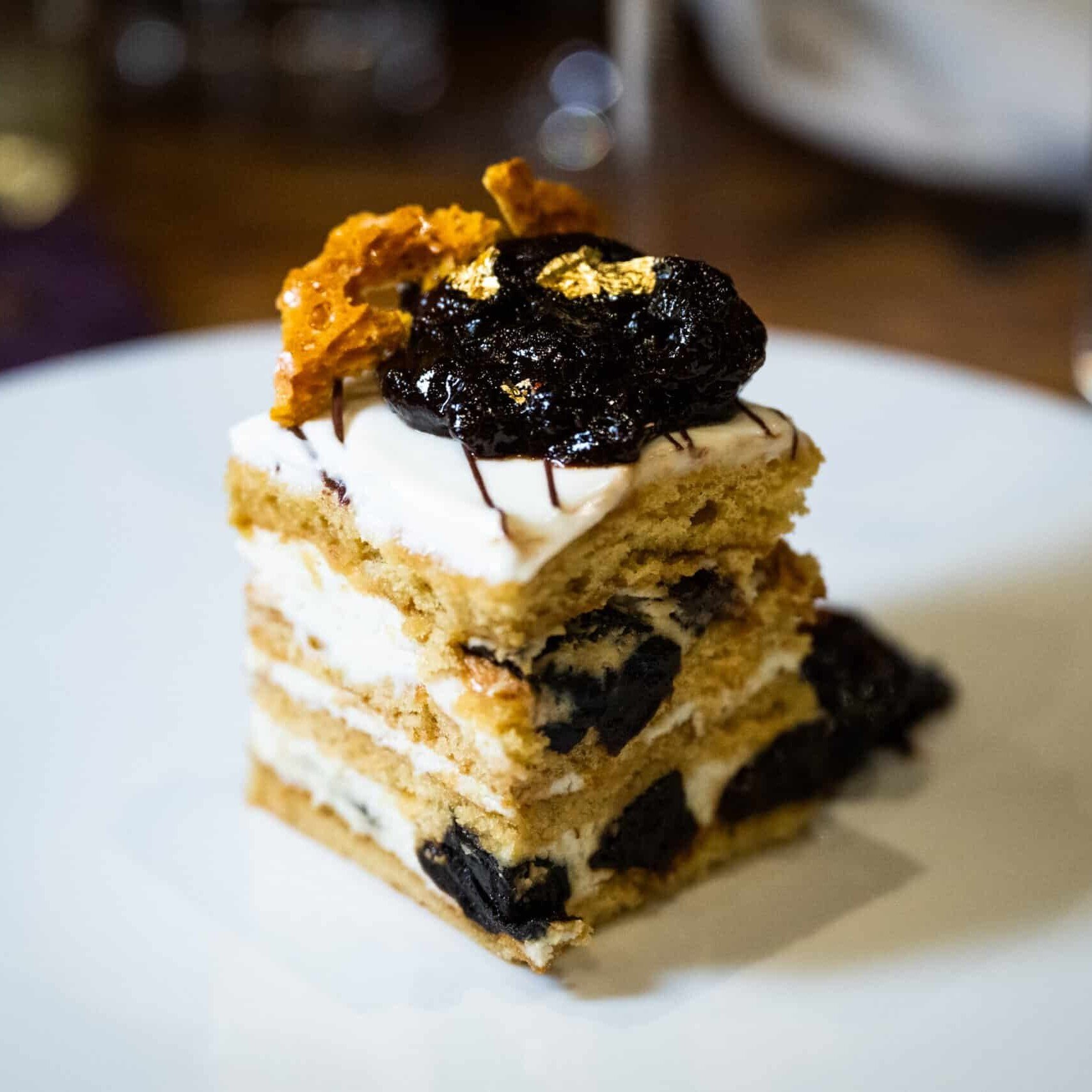 A slice of California Prune and Ukranian Honey Cake on a white plate