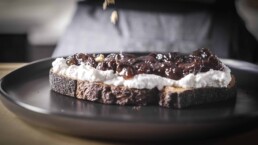 Five Spice California Prune Jam on top a a piece of toast with ricotta