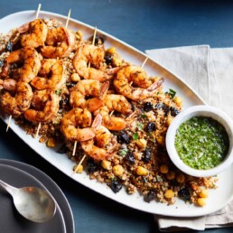 a plate of Moroccan Spiced Shrimp Skewers on top of a bed of rice