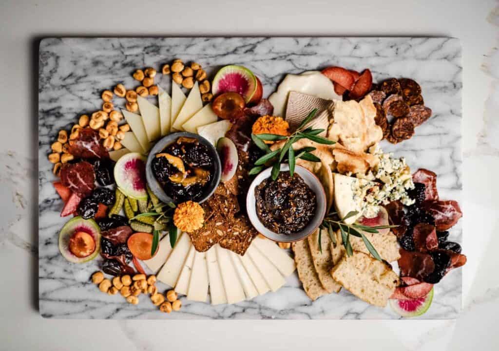 The Ultimate Cheese Board with Pink Peppercorn Prune Syrup, Prune Mostarda, cheeses fruit and corn nuts