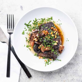 a white plate of Stephanie Cmar's short ribs with a fork and knife
