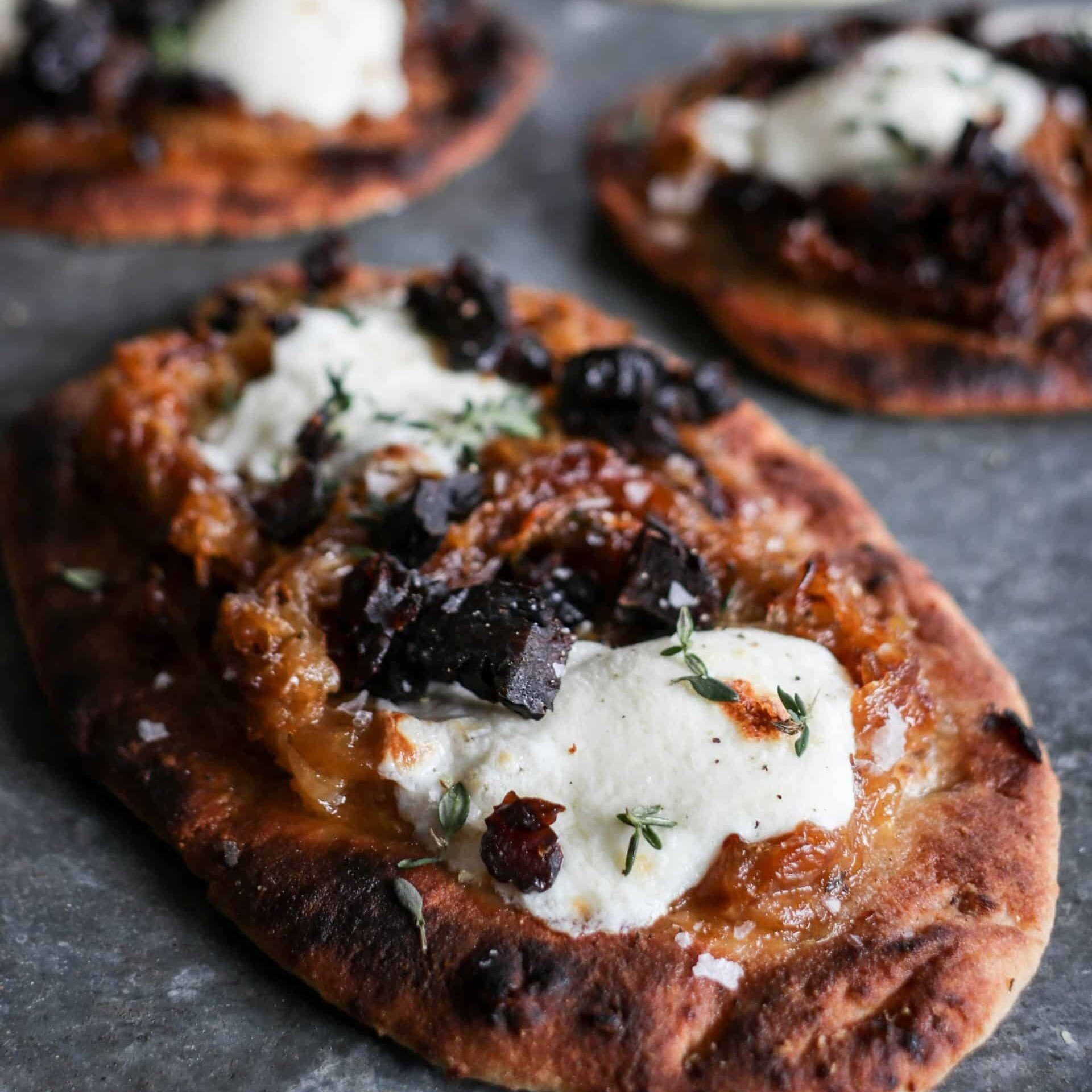 close up of Prune flatbread with mozzarella, caramelized onions and thyme