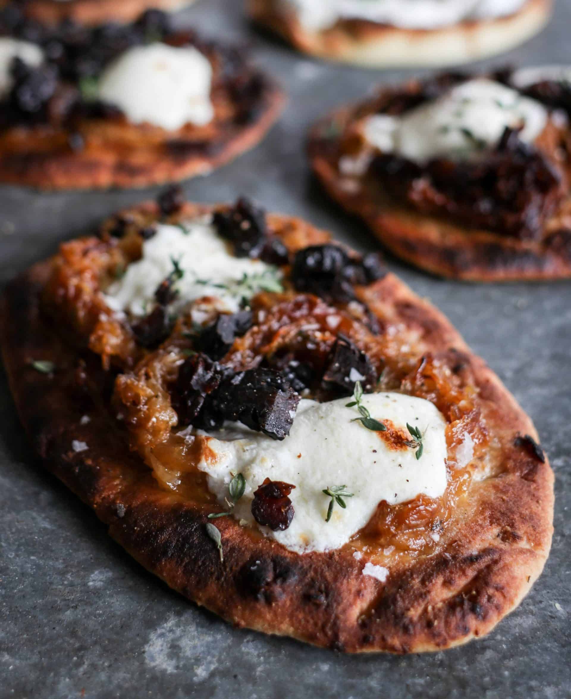 close up of Prune flatbread with mozzarella, caramelized onions and thyme