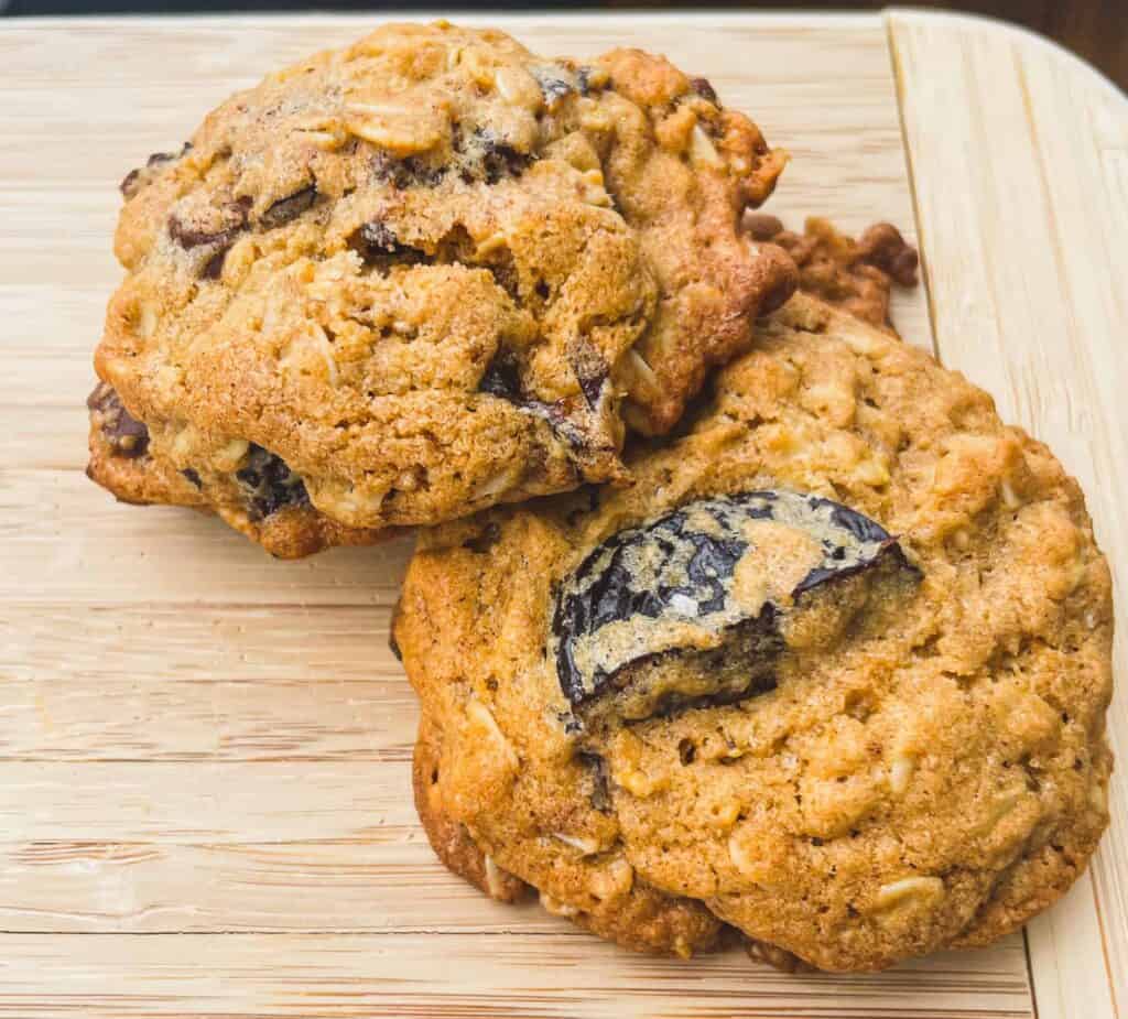Two of Aliza Sokolow's Chocolate Chunk Cookies on a wooden cutting board