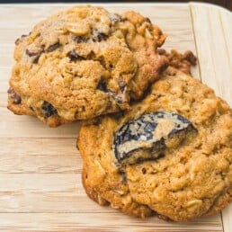 Two of Aliza Sokolow's Chocolate Chunk Cookies on a wooden cutting board