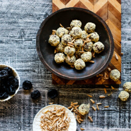 Prune, Almond and Chocolate Truffles in a bowl shown with bowls of prunes and slivered almonds