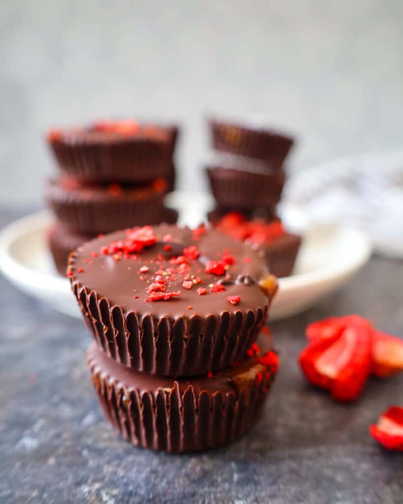 a stack of caramel-filled chocolate candy cups with dehydrated strawberries on top