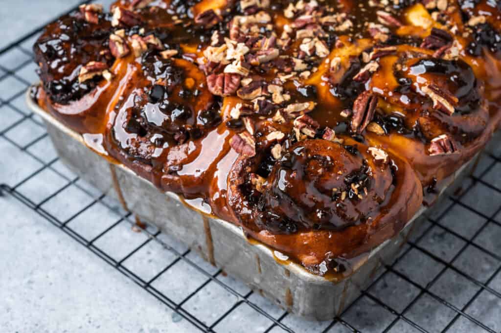 A metal pan with freshly baked Incredible Sticky Buns on a cooling rack