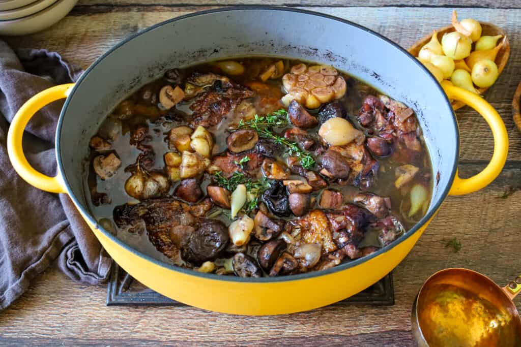 a yellow pan filled with Coq au Vin