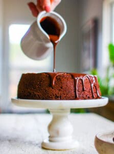 drizzling ganache on top of the chocolate cake