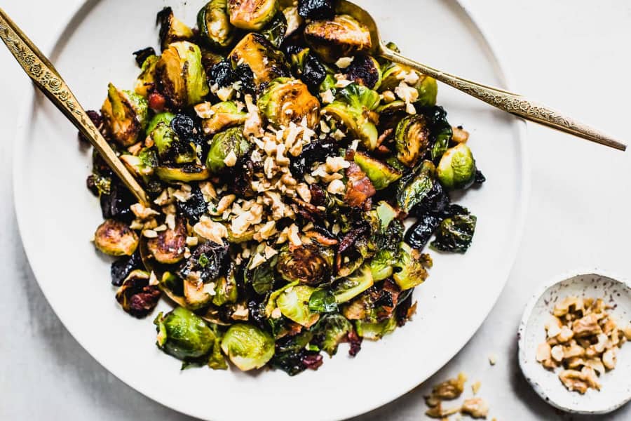 a plate full of Sweet and Salty Brussels Sprouts with a spoon from Heartbeet Kitchen