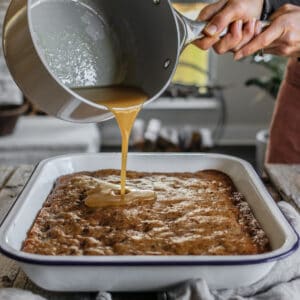 pouring glaze on an old-fashioned prune cake