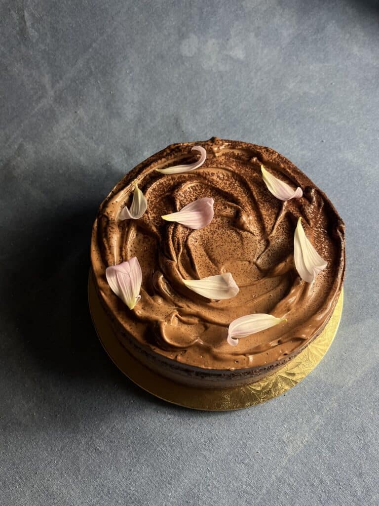 Chocolate Walnut Chiffon Cake with Prunes and Chicory Cream topped with edible flowers