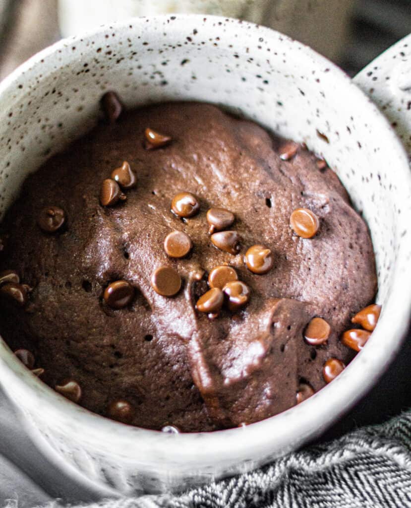 a mug full of chocolate cake topped with chocolate chips