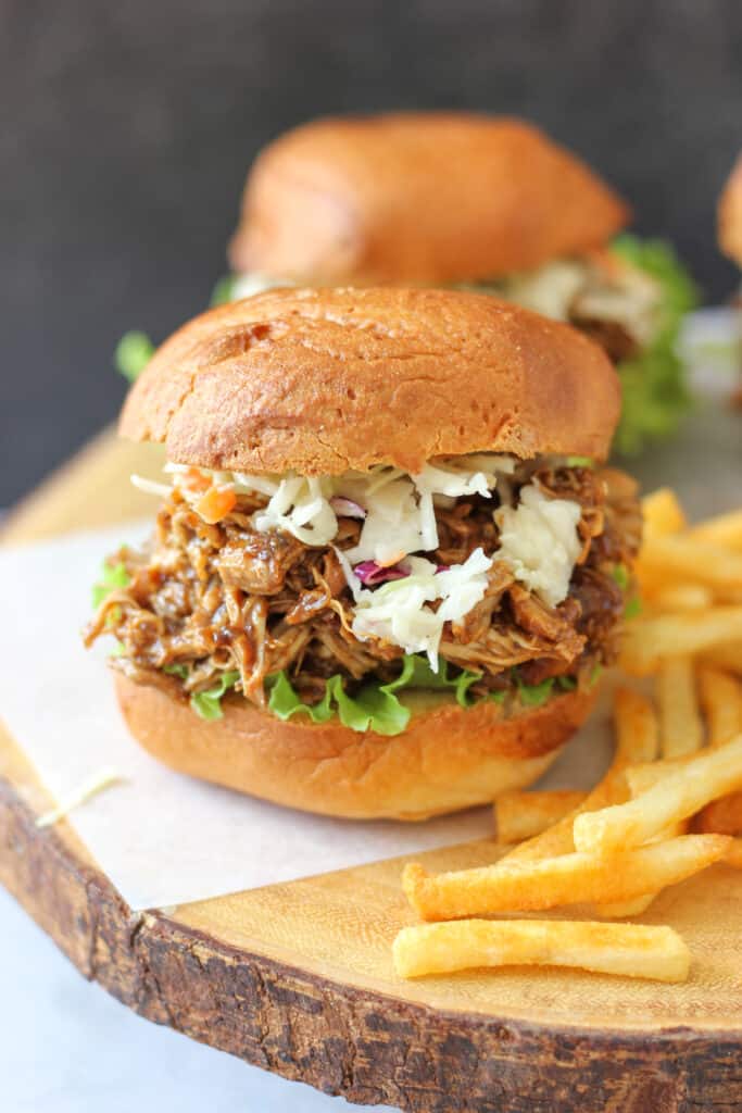 BBQ pulled chicken sandwiches  with coleslaw on a plate with french fries
