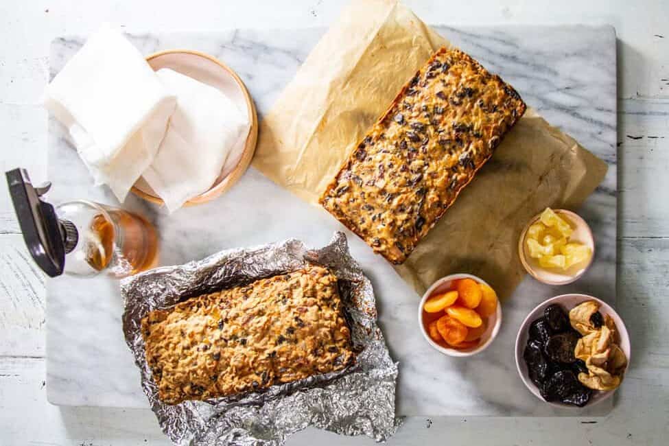 two loafs of Fruitcake from this Mess is ours surrounded by bowls of dried fruit