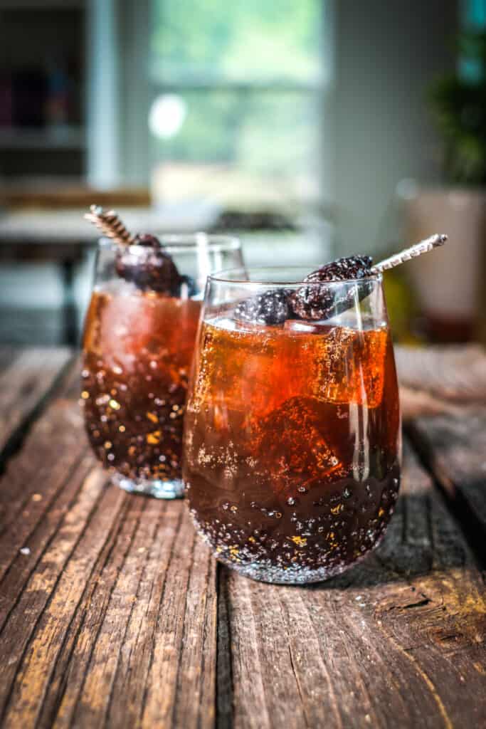 two glasses of Stormy Sparklers garnished with blackberries