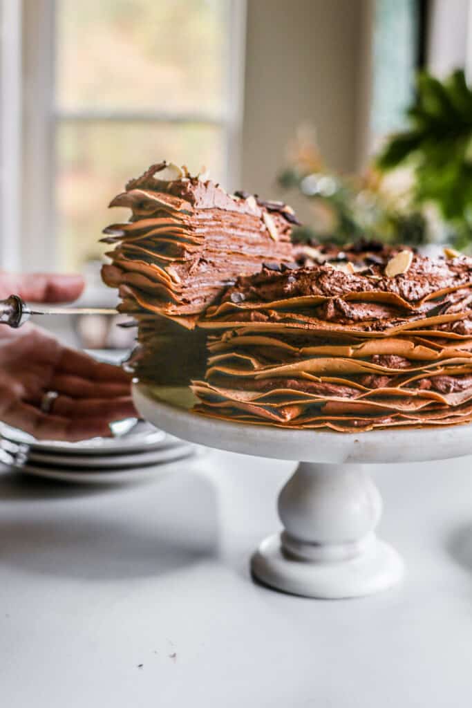 pulling a slice of chocolate crepe cake