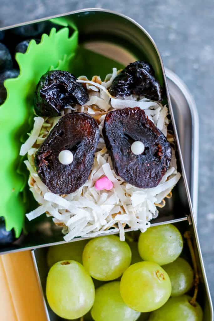 A pumpkin muffin decorated with dried fruit and candy to look like a Panda