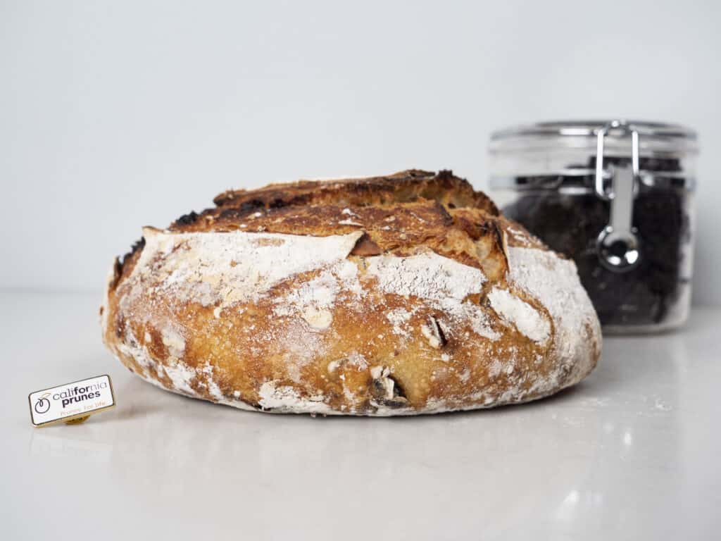 a loaf of Sourdough Bread  and a jar of prunes