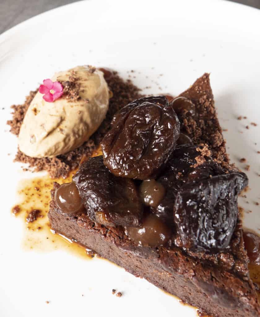 a close up of a chocolate torte and a scoop of brandy ice cream