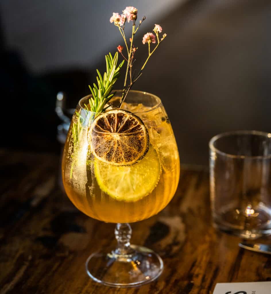 Finely Pruned Cocktail in a glass with citrus slices and herbs