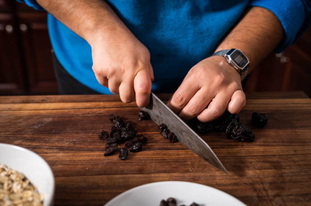 chopped prunes - man chopping prunes with a knife