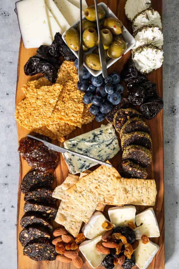 Vegan Salami slices on a grazeboard with olives, crackers and cheeses