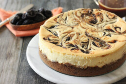 A cheesecake with salted caramel swirl and a bowl of prunes