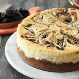 A cheesecake with salted caramel swirl and a bowl of prunes