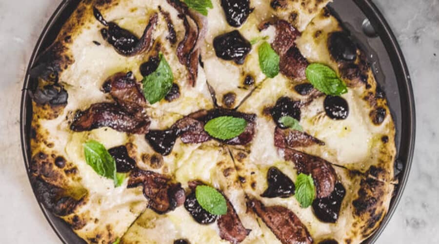 a pizza pan with california prune pizza with bacon jam from Sunset Magazine