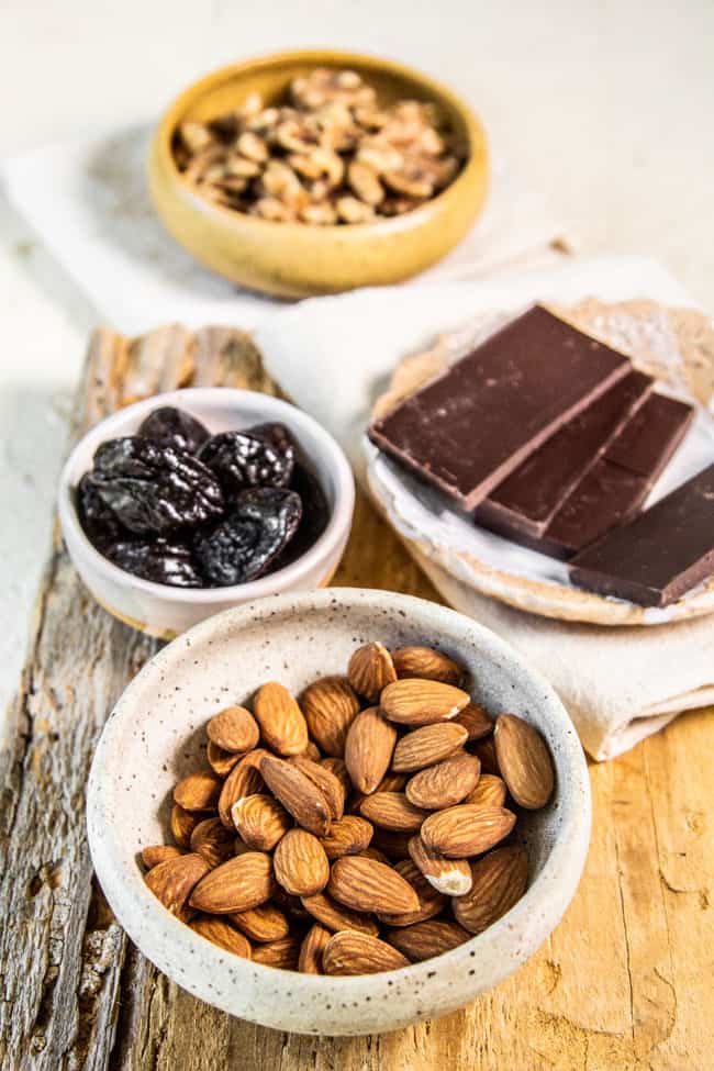 ingredients used to make heart healthy trail mix - dark chocolate, almonds, prunes and walnuts