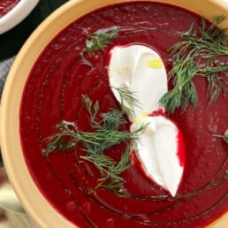a bowl of Ukrainian Borscht topped with creme fraiche and dill