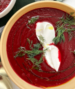 a bowl of Ukrainian Borscht topped with creme fraiche and dill