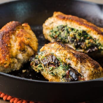 a cast iron pan filled with stuffed chicken breasts