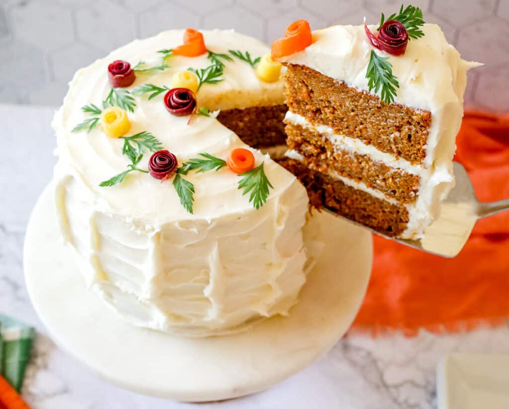 pulling out a slice of Carrot Cake from the layer cake