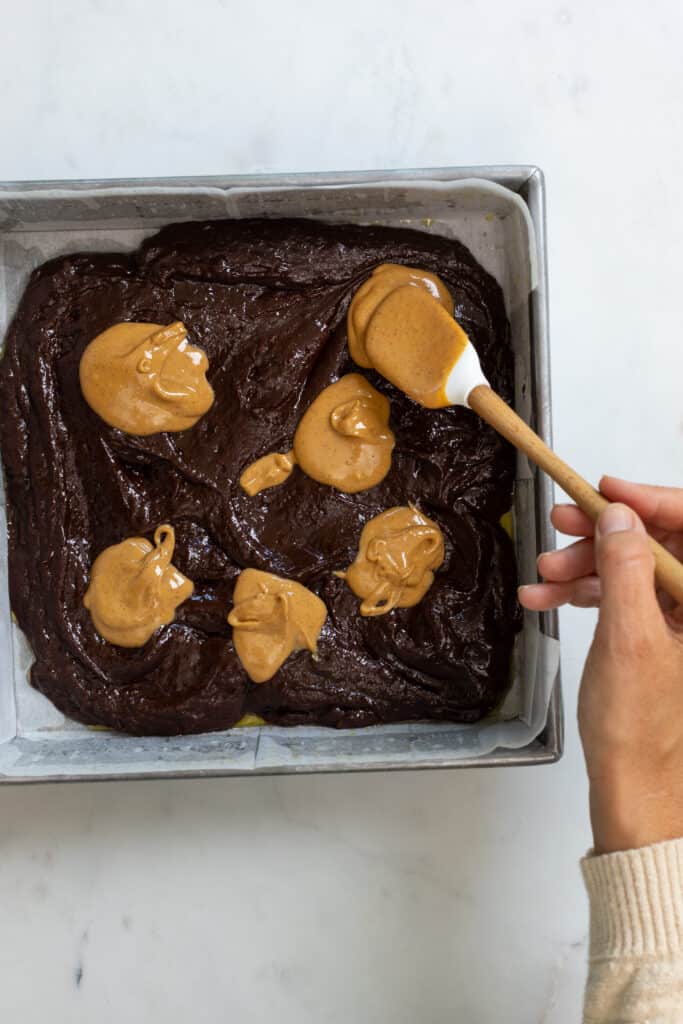 swirling peanut butter into chocolate brownies