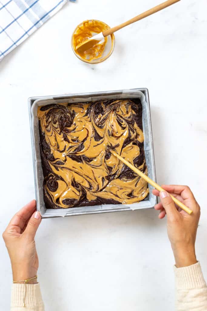 swirling peanut butter into chocolate brownies