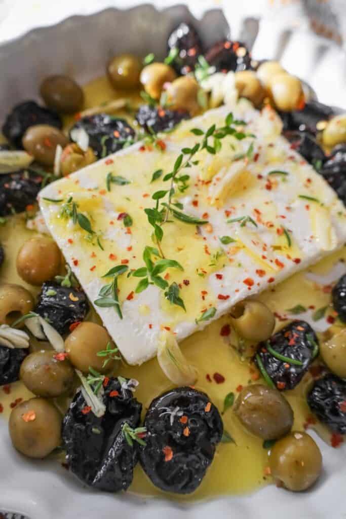 baked feta drizzled with olive oil and sprinkled with herbs before baking