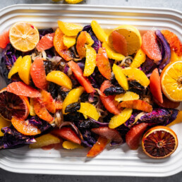 a serving dish of roasted cabbage with prunes and citrus