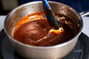 adding butter to homemade barbeque sauce recipe