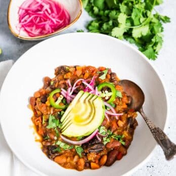 Accidentally Vegan Vegetarian Chili featuring California Prunes | Opt-in content Accidentally Vegan Vegetarian Chili featuring California Prunes garnished with sliced avocado and pickled onions
