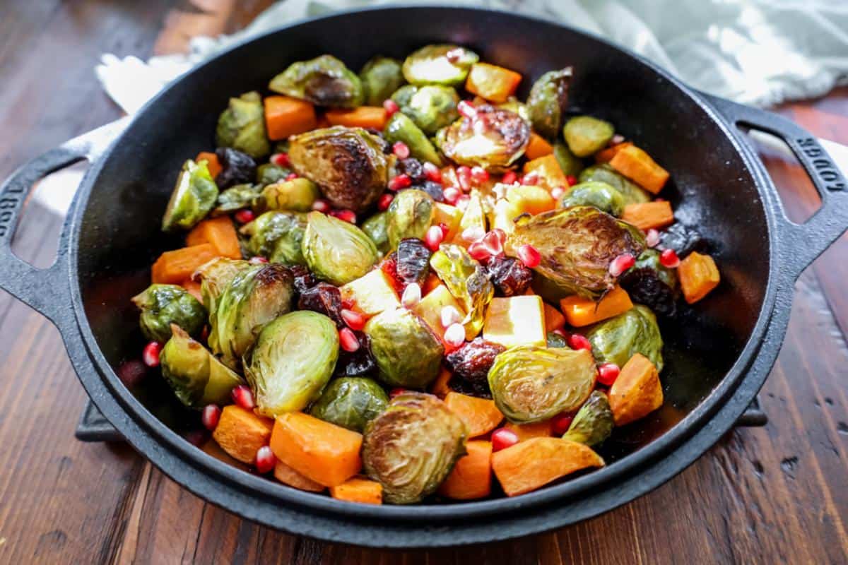 roasted brussels sprouts with sweet potatoes and garnished with pomegranate arils